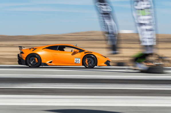 Oranje Lamborghini Huracán op volle snelheid tijdens een sprintrace